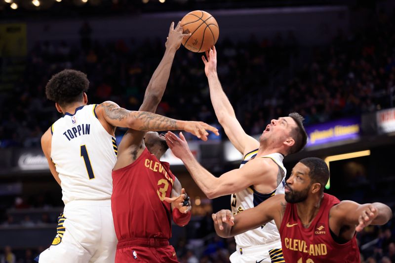 INDIANAPOLIS, INDIANA - MARCH 18: Caris LeVert #3 of the Cleveland Cavaliers and T.J. McConnell #9 of the Indiana Pacers battle for a rebound during the first half at Gainbridge Fieldhouse on March 18, 2024 in Indianapolis, Indiana. NOTE TO USER: User expressly acknowledges and agrees that, by downloading and or using this photograph, User is consenting to the terms and conditions of the Getty Images License Agreement. (Photo by Justin Casterline/Getty Images)