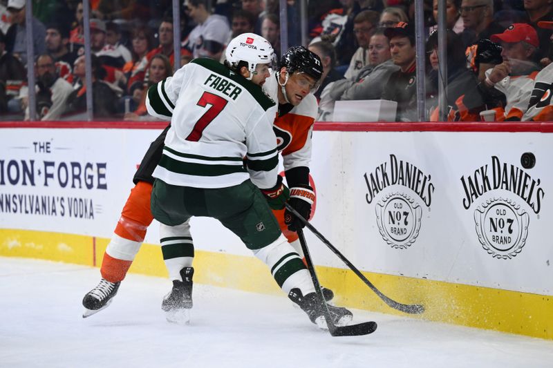 Oct 26, 2024; Philadelphia, Pennsylvania, USA; Minnesota Wild defenseman Brock Faber (7) and Philadelphia Flyers defenseman Erik Johnson (77) battle for the puck in the second period at Wells Fargo Center. Mandatory Credit: Kyle Ross-Imagn Images