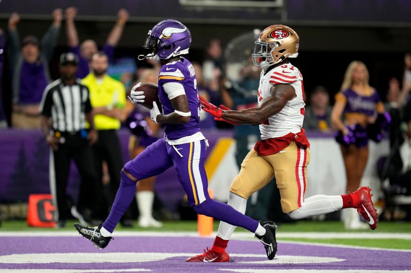 Minnesota Vikings wide receiver Jordan Addison, left, catches a 20-yard touchdown pass ahead of San Francisco 49ers linebacker Dre Greenlaw, right, during the first half of an NFL football game, Monday, Oct. 23, 2023, in Minneapolis. (AP Photo/Abbie Parr)