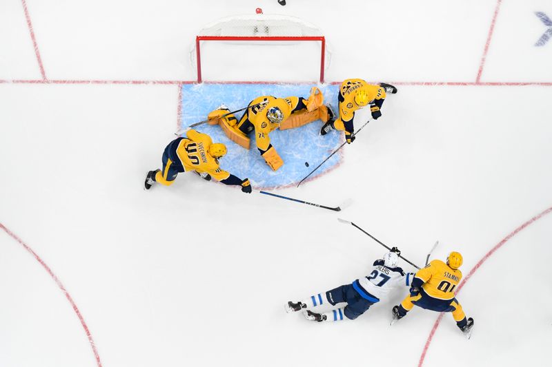 Nov 23, 2024; Nashville, Tennessee, USA;  Nashville Predators goaltender Juuse Saros (74) blocks the shot of Winnipeg Jets left wing Nikolaj Ehlers (27) during the first period at Bridgestone Arena. Mandatory Credit: Steve Roberts-Imagn Images