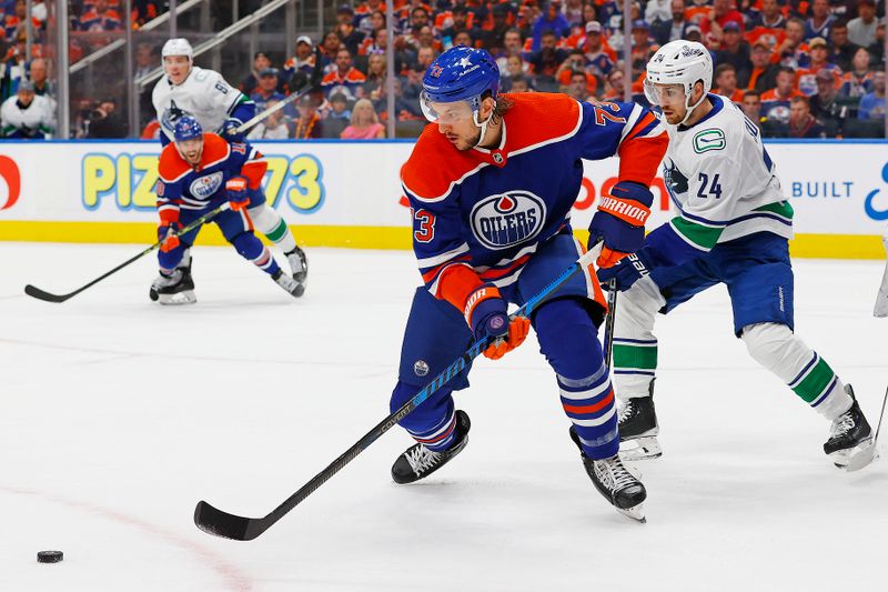 May 14, 2024; Edmonton, Alberta, CAN; Edmonton Oilers defensemen Vincent Desharnais (73) clears a loose puck in front of Vancouver Canucks forward Pius Suter (24) during the second period in game four of the second round of the 2024 Stanley Cup Playoffs at Rogers Place. Mandatory Credit: Perry Nelson-USA TODAY Sports