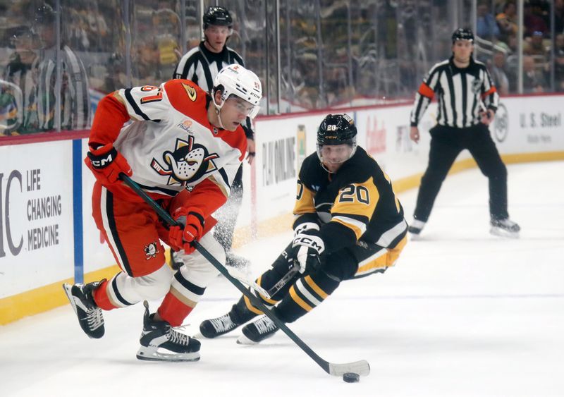 Oct 31, 2024; Pittsburgh, Pennsylvania, USA;  Anaheim Ducks left wing Cutter Gauthier (61) moves the puck ahead of Pittsburgh Penguins center Lars Eller (20) during the second period at PPG Paints Arena. Mandatory Credit: Charles LeClaire-Imagn Images