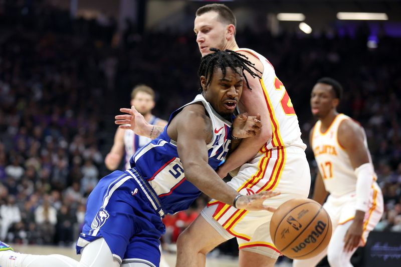 SACRAMENTO, CALIFORNIA - JANUARY 22: Davion Mitchell #15 of the Sacramento Kings is guarded by Garrison Mathews #25 of the Atlanta Hawks in the first half at Golden 1 Center on January 22, 2024 in Sacramento, California. NOTE TO USER: User expressly acknowledges and agrees that, by downloading and or using this photograph, User is consenting to the terms and conditions of the Getty Images License Agreement.  (Photo by Ezra Shaw/Getty Images)