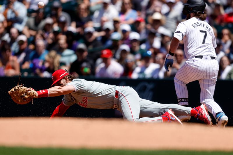 May 26, 2024; Denver, Colorado, USA; Philadelphia Phillies first baseman Bryce Harper (3) is unable to field a throw to first against Colorado Rockies second baseman Brendan Rodgers (7) in the second inning at Coors Field. Mandatory Credit: Isaiah J. Downing-USA TODAY Sports