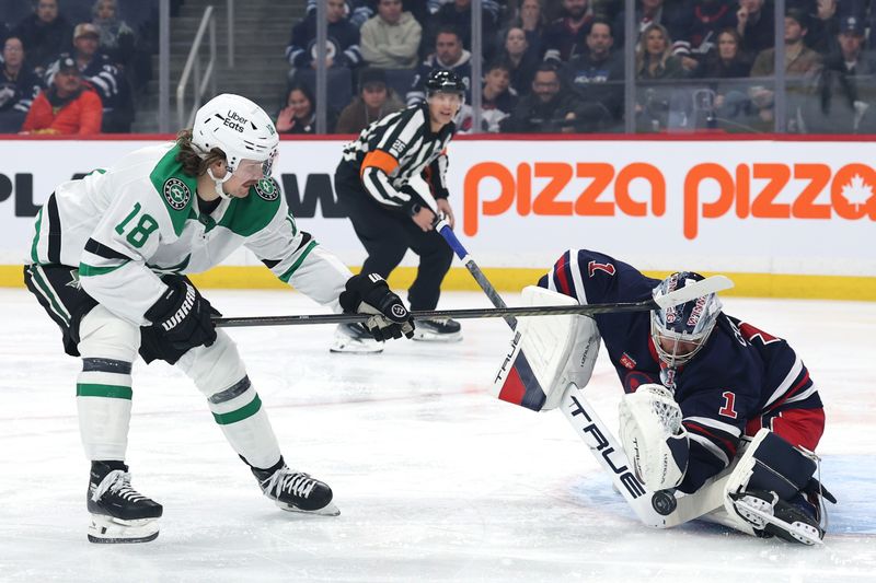 Dec 9, 2025; Winnipeg, Manitoba, CAN; Winnipeg Jets goaltender Eric Comrie (1) blocks a shot from Dallas Stars center Sam Steel (18) in the first period at Canada Life Centre. Mandatory Credit: James Carey Lauder-Imagn Images