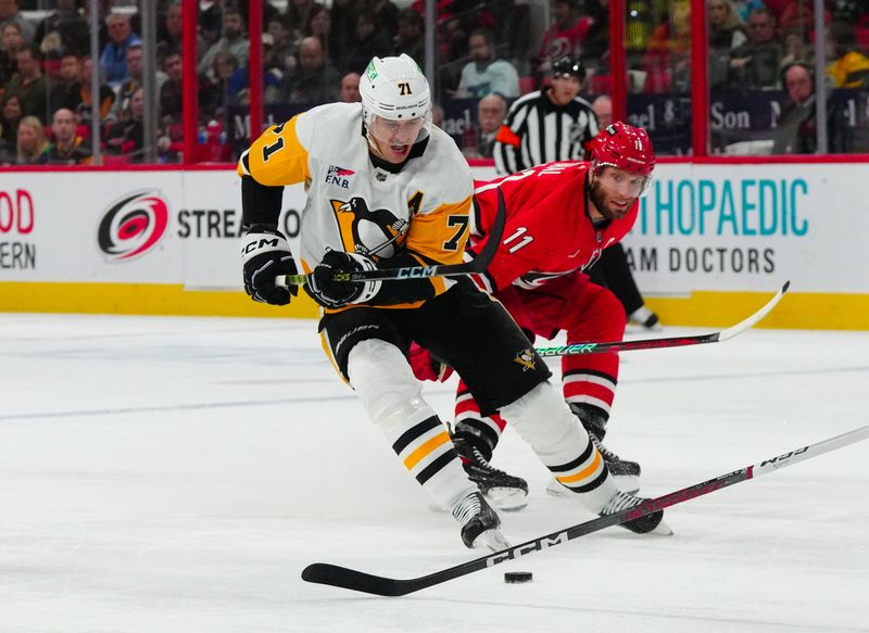 Jan 13, 2024; Raleigh, North Carolina, USA;  Pittsburgh Penguins center Evgeni Malkin (71) skates with the pick past Carolina Hurricanes center Jordan Staal (11) during the second period at PNC Arena. Mandatory Credit: James Guillory-USA TODAY Sports