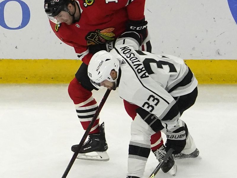 Jan 22, 2023; Chicago, Illinois, USA; Los Angeles Kings right wing Viktor Arvidsson (33) and Chicago Blackhawks right wing Taylor Raddysh (11) go for the puck during the first period at United Center. Mandatory Credit: David Banks-USA TODAY Sports