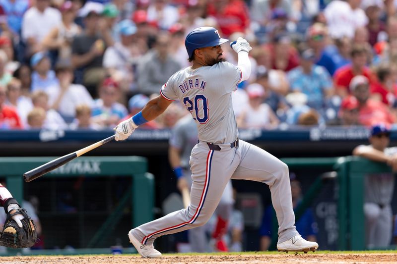 May 23, 2024; Philadelphia, Pennsylvania, USA; Texas Rangers first base Ezequiel Duran (20) hits an RBI single during the seventh inning against the Philadelphia Phillies at Citizens Bank Park. Mandatory Credit: Bill Streicher-USA TODAY Sports