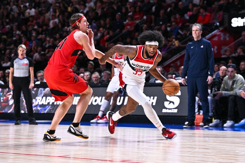 MONTREAL, CANADA - OCTOBER 06: Marvin Bagley III #35 of the Washington Wizards dribbles the ball against Kelly Olynyk #41 of the Toronto Raptors during the second half of a preseason NBA game at the Bell Centre on October 6, 2024 in Montreal, Quebec, Canada. The Toronto Raptors defeated the Washington Wizards 125-98. NOTE TO USER: User expressly acknowledges and agrees that, by downloading and or using this photograph, User is consenting to the terms and conditions of the Getty Images License Agreement. (Photo by Minas Panagiotakis/Getty Images)