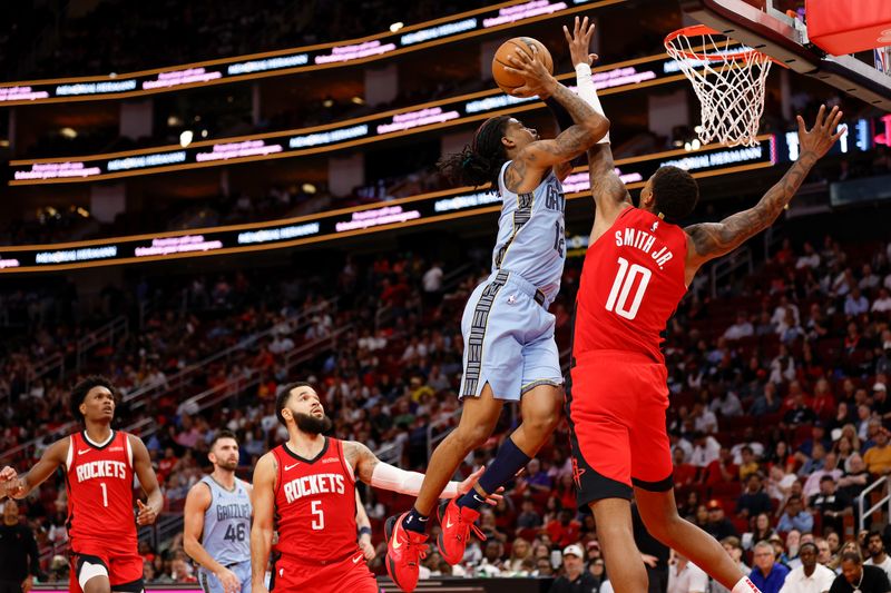 HOUSTON, TEXAS - OCTOBER 25: Ja Morant #12 of the Memphis Grizzlies drives to the basket while defended by Jabari Smith Jr. #10 of the Houston Rockets in the second half at Toyota Center on October 25, 2024 in Houston, Texas.  NOTE TO USER: User expressly acknowledges and agrees that, by downloading and or using this photograph, User is consenting to the terms and conditions of the Getty Images License Agreement.  (Photo by Tim Warner/Getty Images)