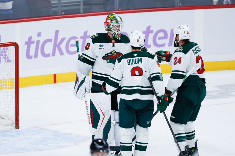 Nov 23, 2025; Winnipeg, Manitoba, CAN;  Minnesota Wild goalie Jesper Wallstedt (30) is congratulated by his team mates on his win against the Winnipeg Jets during the third period at Canada Life Centre. Mandatory Credit: Terrence Lee-Imagn Images