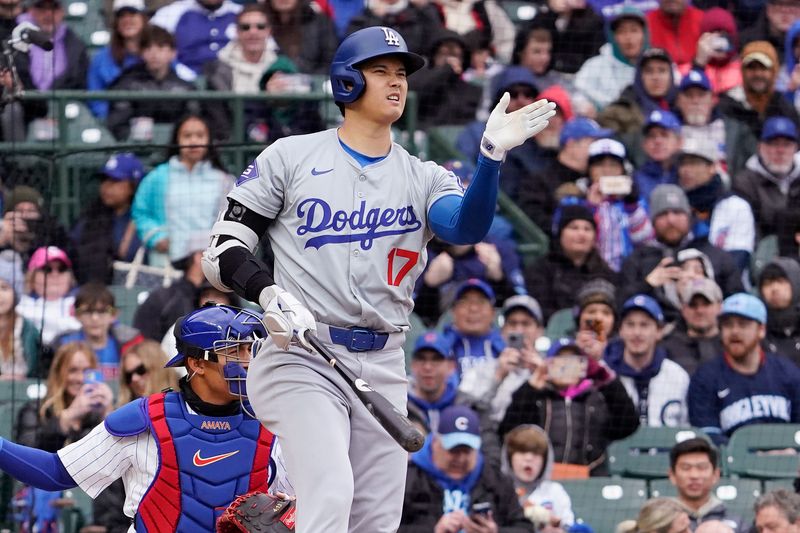 Apr 7, 2024; Chicago, Illinois, USA; Los Angeles Dodgers designated hitter Shohei Ohtani (17) gestures to try and straighten out a foul ball against the Chicago Cubs during the first inningat Wrigley Field. Mandatory Credit: David Banks-USA TODAY Sports