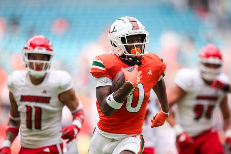 Nov 18, 2023; Miami Gardens, Florida, USA; Miami Hurricanes wide receiver Brashard Smith (0) runs with the football for a touchdown against the Louisville Cardinals during the second quarter at Hard Rock Stadium. Mandatory Credit: Sam Navarro-USA TODAY Sports