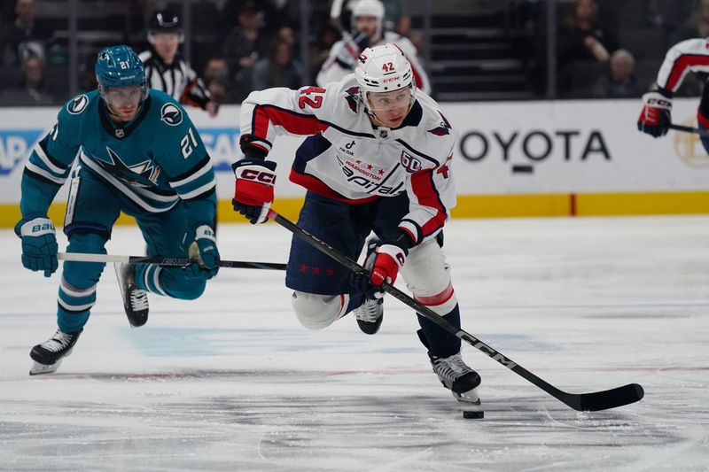Mar 15, 2025; San Jose, California, USA;  Washington Capitals defenseman Martin Fehervary (42) advances the puck against San Jose Sharks center Alexander Wennberg (21) in the first period at SAP Center at San Jose. Mandatory Credit: David Gonzales-Imagn Images