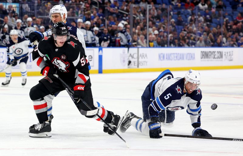 Mar 3, 2024; Buffalo, New York, USA;  Winnipeg Jets defenseman Brenden Dillon (5) dives to knock the puck off the stick of Buffalo Sabres left wing Eric Robinson (50) during the second period at KeyBank Center. Mandatory Credit: Timothy T. Ludwig-USA TODAY Sports