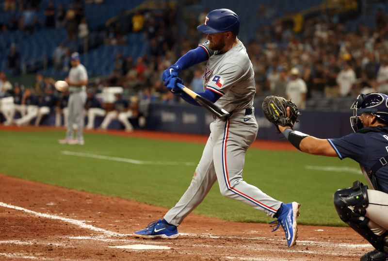 Apr 2, 2024; St. Petersburg, Florida, USA; Texas Rangers first baseman Jared Walsh (21) singles during the ninth inning against the Tampa Bay Rays at Tropicana Field. Mandatory Credit: Kim Klement Neitzel-USA TODAY Sports