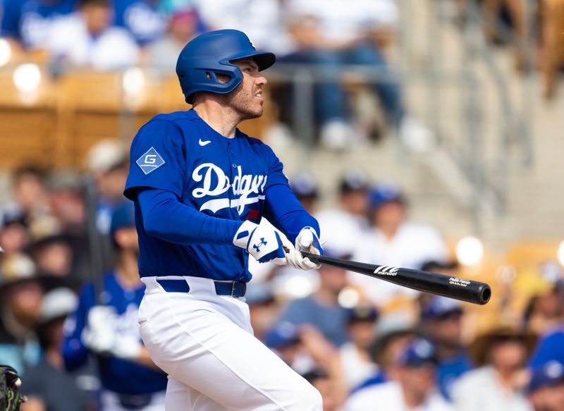 Mar 1, 2026; Phoenix, Arizona, USA; Los Angeles Dodgers first baseman Freddie Freeman hits a double against the Los Angeles Angels during a spring training game at Camelback Ranch-Glendale. Mandatory Credit: Mark J. Rebilas-Imagn Images