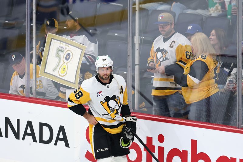 Nov 1, 2025; Winnipeg, Manitoba, CAN; Pittsburgh Penguins defenseman Kris Letang (58) skates past fans before a game against the Winnipeg Jets at Canada Life Centre. Mandatory Credit: James Carey Lauder-Imagn Images