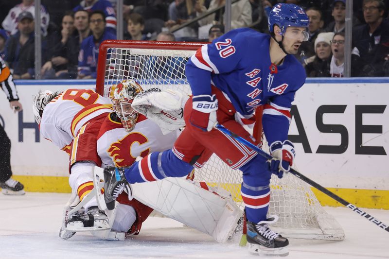 Feb 12, 2024; New York, New York, USA; Calgary Flames defenseman Chris Tanev (8) collides with goaltender Jacob Markstrom (25) as they fight for the puck against New York Rangers left wing Chris Kreider (20) during the first period at Madison Square Garden. Mandatory Credit: Brad Penner-USA TODAY Sports