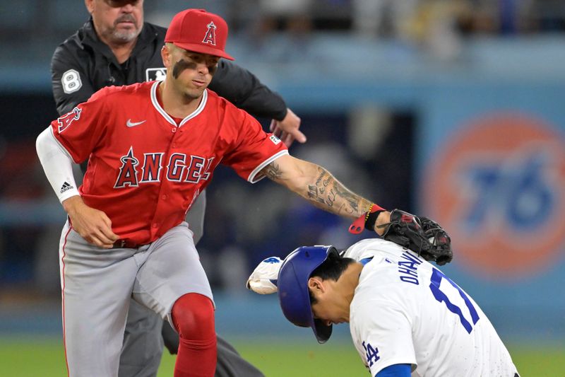 Jun 21, 2024; Los Angeles, California, USA;  Los Angeles Dodgers designated hitter Shohei Ohtani (17) is tagged out by Los Angeles Angels shortstop Zach Neto (9) on an attempted stolen base in the eighth inning at Dodger Stadium. Mandatory Credit: Jayne Kamin-Oncea-USA TODAY Sports