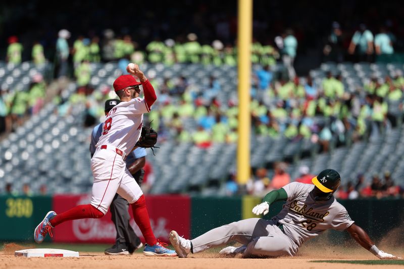 Jun 26, 2024; Anaheim, California, USA;  Los Angeles Angels shortstop Zach Neto (9) throws to first as Oakland Athletics center fielder Daz Cameron (28) is out at second on a double play during the eighth inning at Angel Stadium. Mandatory Credit: Kiyoshi Mio-USA TODAY Sports
