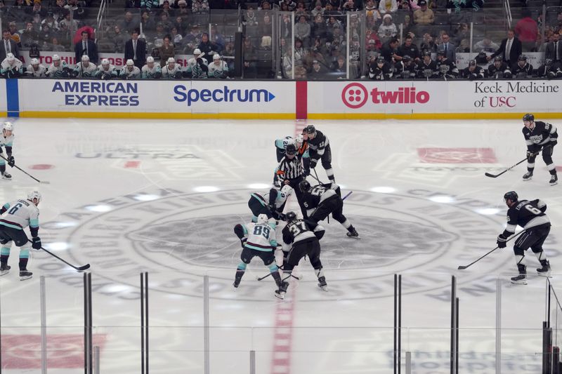 Dec 23, 2025; Los Angeles, California, USA; NHL referee Wes McCauley (4) drops the puck on the opening faceoff between Seattle Kraken center Chandler Stephenson (9) and LA Kings right wing Quinton Byfield (55) at Crypto.com Arena. Mandatory Credit: Kirby Lee-Imagn Images