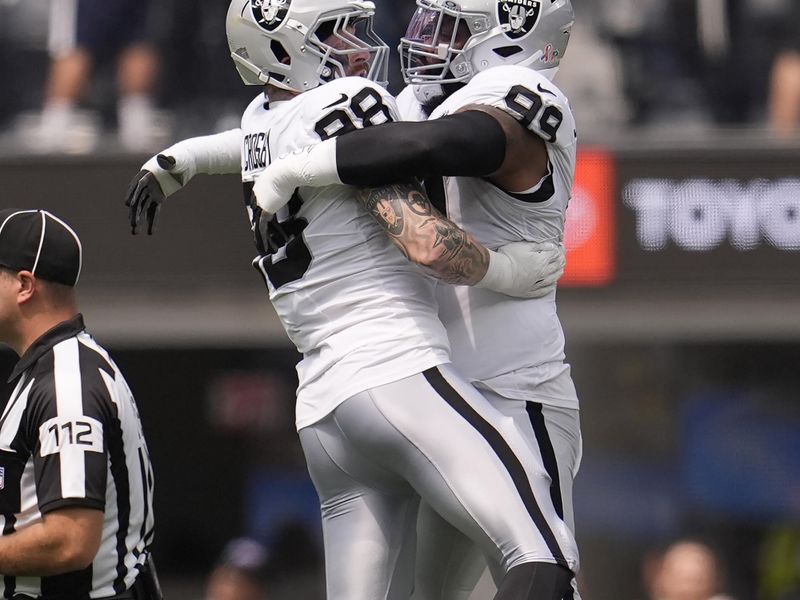 Las Vegas Raiders defensive end Maxx Crosby, left, celebrates with defensive tackle Nesta Jade Silvera after sacking Los Angeles Chargers quarterback Justin Herbert during the first half of an NFL football game, Sunday, Sept. 8, 2024, in Inglewood, Calif. (AP Photo/Marcio Jose Sanchez)