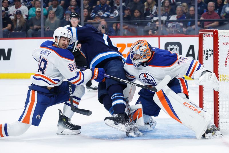 Sep 25, 2024; Winnipeg, Manitoba, CAN; Winnipeg Jets goalie Arvid Holm (75) jostles for position with Edmonton Oilers defenseman Max Wanner (88) in front of Edmonton Oilers goalie Stuart Skinner (74) during the second period at Canada Life Centre. Mandatory Credit: Terrence Lee-Imagn Images