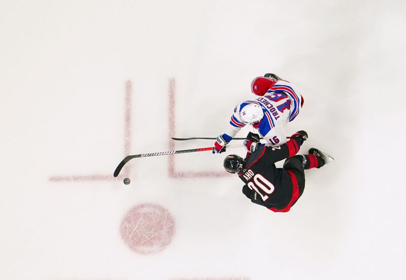 Mar 12, 2024; Raleigh, North Carolina, USA; Carolina Hurricanes center Sebastian Aho (20) and New York Rangers center Vincent Trocheck (16) battle over the puck during the second period at PNC Arena. Mandatory Credit: James Guillory-USA TODAY Sports