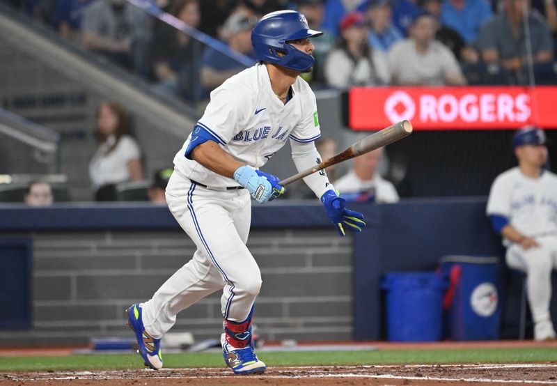 Jun 4, 2025; Toronto, Ontario, CAN;  Toronto Blue Jays second baseman Andres Gimenez (0) hits a single against the Philadelphia Phillies in the third inning at Rogers Centre. Mandatory Credit: Dan Hamilton-Imagn Images