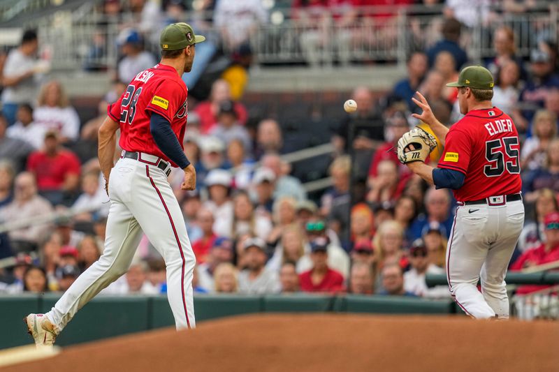 May 19, 2023; Cumberland, Georgia, USA; Atlanta Braves first baseman Matt Olson (28) flips the ball to starting pitcher Bryce Elder (55) for a force out on Seattle Mariners left fielder Jarred Kelenic (10) (not shown)  during the second inning at Truist Park. Mandatory Credit: Dale Zanine-USA TODAY Sports