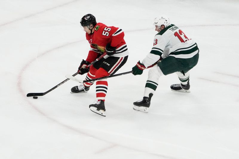 Nov 26, 2025; Chicago, Illinois, USA; Chicago Blackhawks defenseman Artyom Levshunov (55) is defended by Minnesota Wild center Yakov Trenin (13) during the third period at United Center. Mandatory Credit: David Banks-Imagn Images