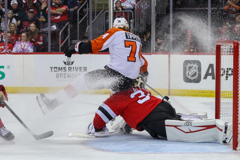 Jan 18, 2025; Newark, New Jersey, USA; Philadelphia Flyers right wing Owen Tippett (74) crashes into New Jersey Devils goaltender Jake Allen (34) during the third period at Prudential Center. Mandatory Credit: Ed Mulholland-Imagn Images