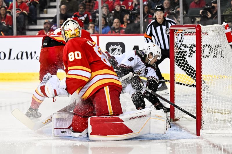 Jan 16, 2024; Calgary, Alberta, CAN; Arizona Coyotes right wing Clayton Keller (9) is taken down by Calgary Flames defenseman Rasmus Andersson (4) as he tries to score on Calgary Flames goaltender Daniel Vladar (80) during the second period at Scotiabank Saddledome. Mandatory Credit: Brett Holmes-USA TODAY Sports