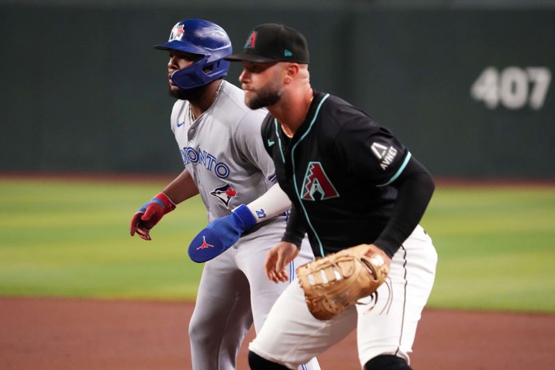 Jul 12, 2024; Phoenix, Arizona, USA; Toronto Blue Jays first base Vladimir Guerrero Jr. (27) leads off first base as Arizona Diamondbacks first base Christian Walker (53) covers the bag during the first inning at Chase Field. Mandatory Credit: Joe Camporeale-USA TODAY Sports