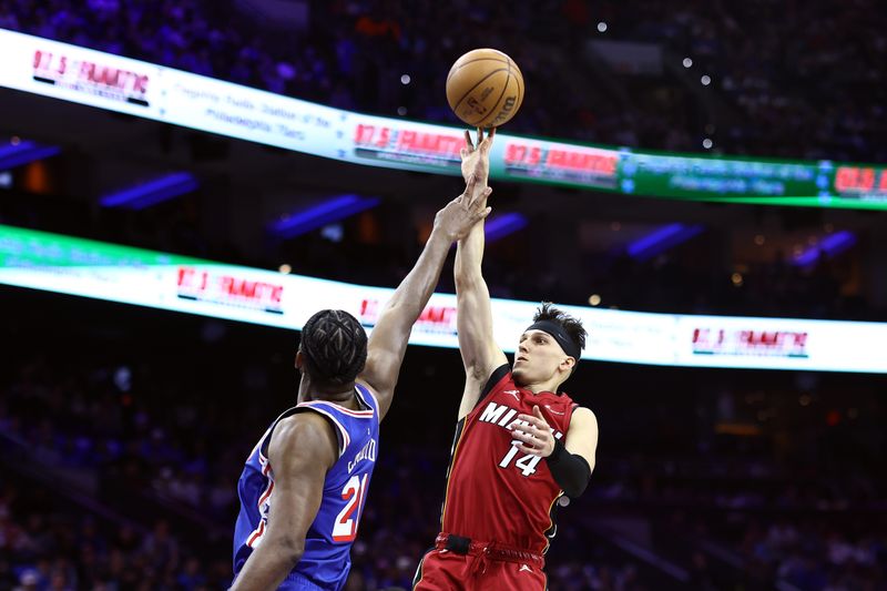 PHILADELPHIA, PENNSYLVANIA - APRIL 17: Tyler Herro #14 of the Miami Heat shoots over Joel Embiid #21 of the Philadelphia 76ers during the third quarter of the Eastern Conference Play-In Tournament at the Wells Fargo Center on April 17, 2024 in Philadelphia, Pennsylvania. NOTE TO USER: User expressly acknowledges and agrees that, by downloading and or using this photograph, User is consenting to the terms and conditions of the Getty Images License Agreement. (Photo by Tim Nwachukwu/Getty Images)