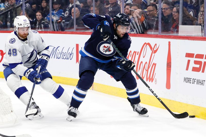 Jan 2, 2024; Winnipeg, Manitoba, CAN; Winnipeg Jets left wing Alex Iafallo (9) is chased down by Tampa Bay Lightning defenseman Nick Perbix (48) in the second period at Canada Life Centre. Mandatory Credit: James Carey Lauder-USA TODAY Sports