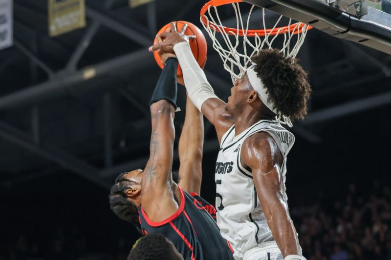 Jan 25, 2023; Orlando, Florida, USA; UCF Knights forward Taylor Hendricks (25) blocks a shot by Houston Cougars forward J'Wan Roberts (13) during the second half1 at Addition Financial Arena. Mandatory Credit: Mike Watters-USA TODAY Sports