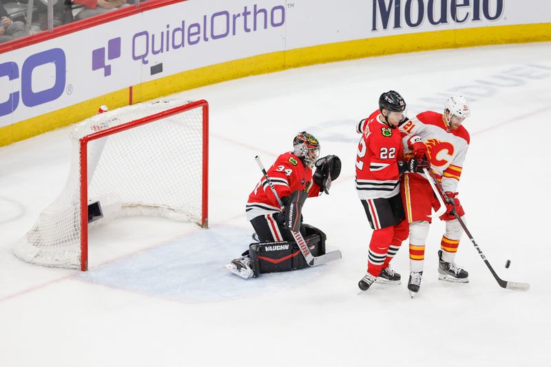 Mar 26, 2024; Chicago, Illinois, USA; Chicago Blackhawks defenseman Nikita Zaitsev (22) defends against Calgary Flames center Kevin Rooney (21) during the second period at United Center. Mandatory Credit: Kamil Krzaczynski-USA TODAY Sports