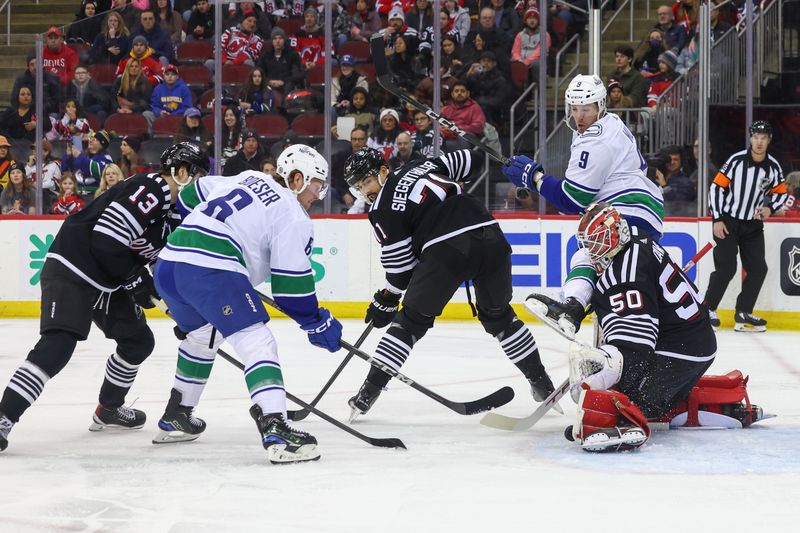 Jan 6, 2024; Newark, New Jersey, USA; New Jersey Devils goaltender Nico Daws (50) makes a save against the Vancouver Canucks during the first period at Prudential Center. Mandatory Credit: Ed Mulholland-USA TODAY Sports