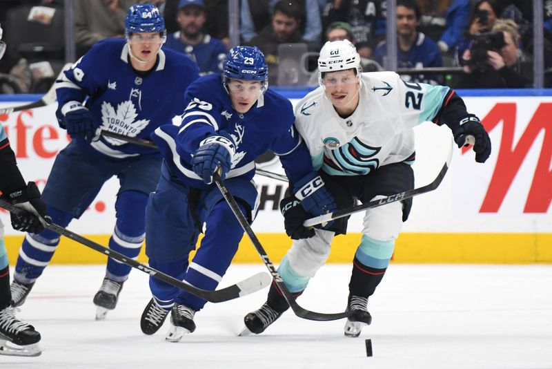 Oct 31, 2024; Toronto, Ontario, CAN;  Seattle Kraken forward Eeli Tolvanen (20) and Toronto Maple Leafs forward Pontus Holmberg (29) pursue the puck in the third period at Scotiabank Arena. Mandatory Credit: Dan Hamilton-Imagn Images