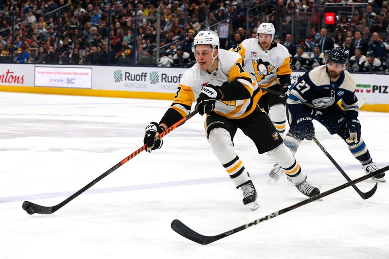 Nov 15, 2024; Columbus, Ohio, USA; Pittsburgh Penguins left wing Drew O'Connor (10) passes the puck as Columbus Blue Jackets center Zach Aston-Reese (27) trails the play during the second period at Nationwide Arena. Mandatory Credit: Russell LaBounty-Imagn Images