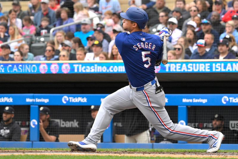 May 26, 2024; Minneapolis, Minnesota, USA;  Texas Rangers infielder Corey Seager (5) hits a two-run home run against the Minnesota Twins during the third inning at Target Field. Mandatory Credit: Nick Wosika-USA TODAY Sports