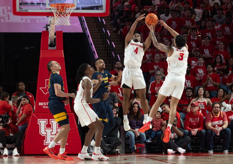 Jan 6, 2024; Houston, Texas, USA; Houston Cougars guard L.J. Cryer (4) and guard Ramon Walker Jr. (3) reach for a rebound against the West Virginia Mountaineers in the second half at Fertitta Center. Mandatory Credit: Thomas Shea-USA TODAY Sports