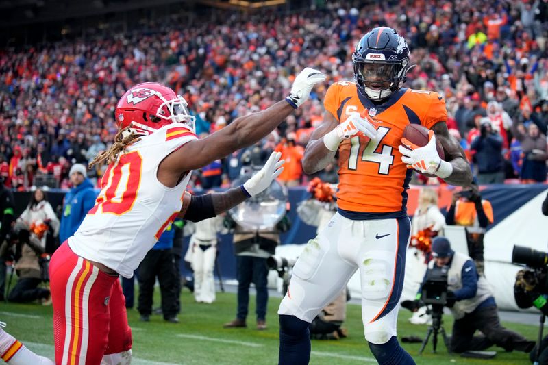 Denver Broncos wide receiver Courtland Sutton (14) catches a touchdown pass as Kansas City Chiefs safety Justin Reid (20) defends during the second half of an NFL football game Sunday, Oct. 29, 2023, in Denver. (AP Photo/David Zalubowski)