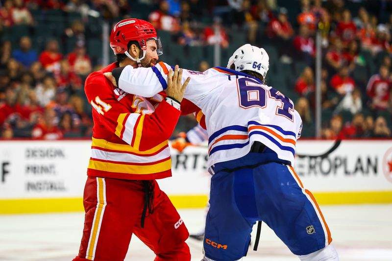 Sep 21, 2025; Calgary, Alberta, CAN; Calgary Flames defenseman Nick Cicek (41) and Edmonton Oilers center Connor Clattenburg (64) fights during the third period at Scotiabank Saddledome. Mandatory Credit: Sergei Belski-Imagn Images
