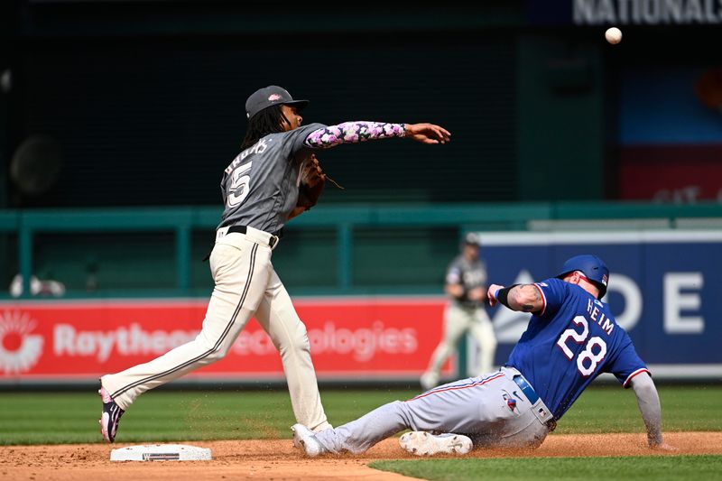 Jul 8, 2023; Washington, District of Columbia, USA; Washington Nationals shortstop CJ Abrams (5) forces out Texas Rangers catcher Jonah Heim (28) during the second inning at Nationals Park. Mandatory Credit: Brad Mills-USA TODAY Sports