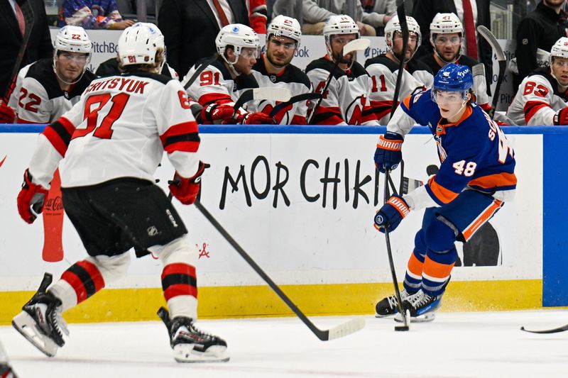 Dec 23, 2025; Elmont, New York, USA;  New York Islanders defenseman Matthew Schaefer (48) plays the puck defended by New Jersey Devils right wing Arseny Gritsyuk (81) during the second period at UBS Arena. Mandatory Credit: Dennis Schneidler-Imagn Images