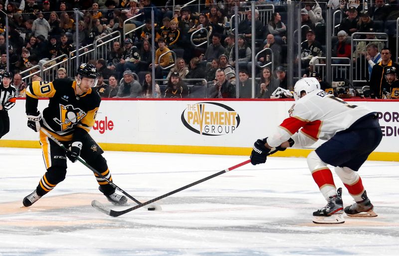 Feb 14, 2024; Pittsburgh, Pennsylvania, USA; Pittsburgh Penguins center Lars Eller (20) skates with the puck as Florida Panthers defenseman Aaron Ekblad (5) defends during the third period at PPG Paints Arena. Florida won 5-2. Mandatory Credit: Charles LeClaire-USA TODAY Sports