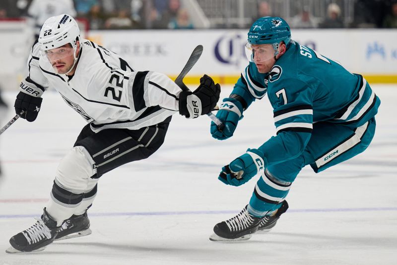 Apr 4, 2024; San Jose, California, USA; Los Angeles Kings left wing Kevin Fiala (22) plays the puck against San Jose Sharks center Nico Sturm (7) during the first period at SAP Center at San Jose. Mandatory Credit: Robert Edwards-USA TODAY Sports